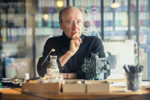Photo représentant le dessinateur, sculpteur et humoriste Philippe Geluck travaillant à sa table à dessin.
